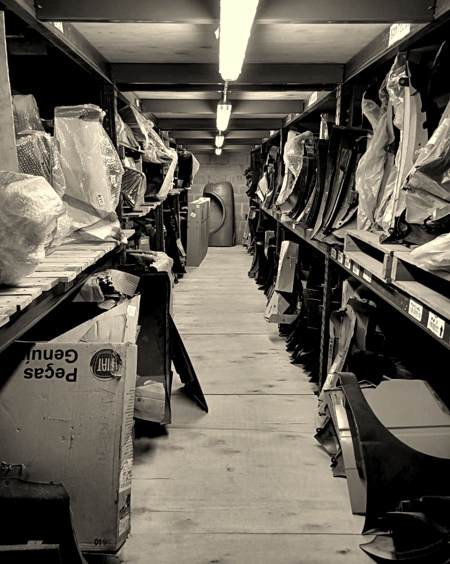 Estanterías del depósito con guardabarros, paragolpes y piezas de carrocería