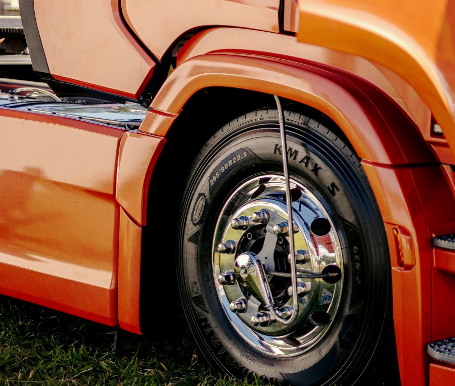 Detalle de guardabarros y rueda de un camión naranja